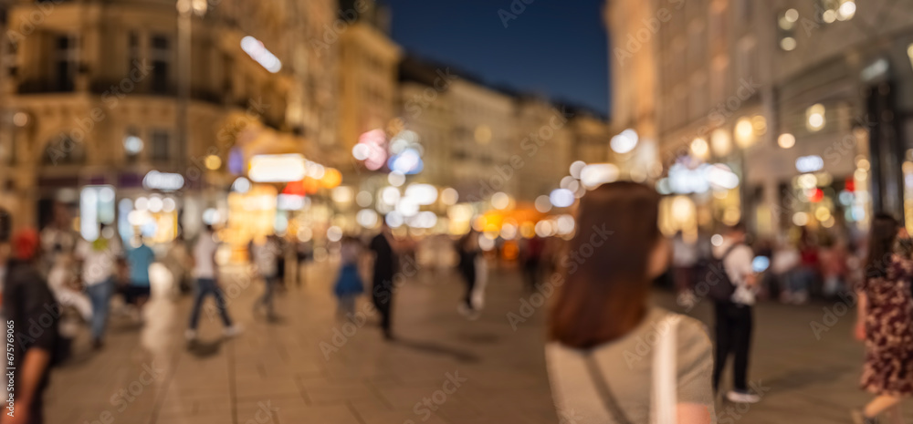 Obraz premium Crowd of anonymous people walking on busy city street at night , urban city life background