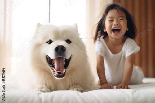 Young asian child playing with samojed dog