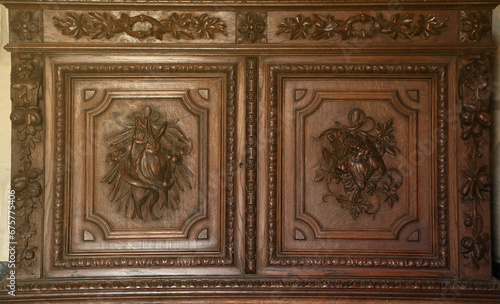 Old vintage wardrobe furniture with ornamental doors and retro colors of wooden surfaces close up © mehaniq41