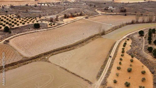 People hiking in mosaic of crops. Drone footage in Castilla la Mancha, land of don quijote, vineyards, flat land, cereals, dirt tracks and paths. Horcajo de Santiago in 4K with DJI Mini 2 photo