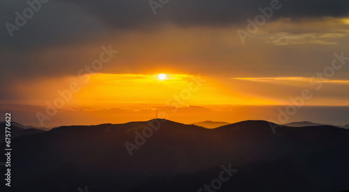 Evening landscape in the mountains at sunset. Last light and clouds at sunset. Natural background. Carpathian Mountains, Ukraine, Europe.