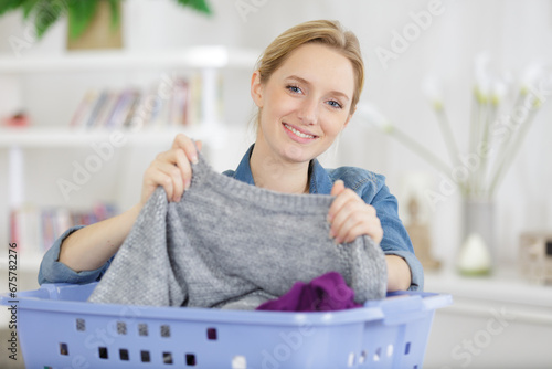 Photos cheerful pretty woman sorting the laundry