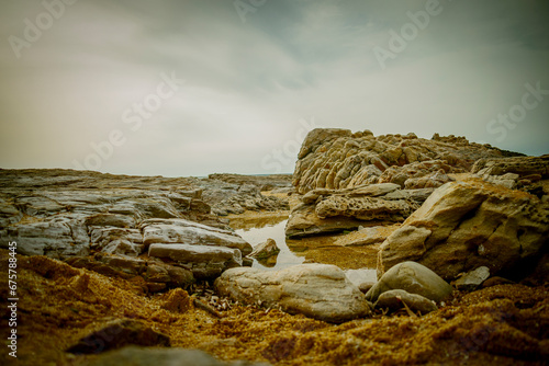 Questa immagine mostra una spiaggia paradisiaca con montagne sullo sfondo. La spiaggia è ricoperta di sabbia bianca e fine, e l'acqua è limpida e turchese. Pistis. photo