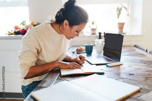 Woman sketching in a book at a table photo