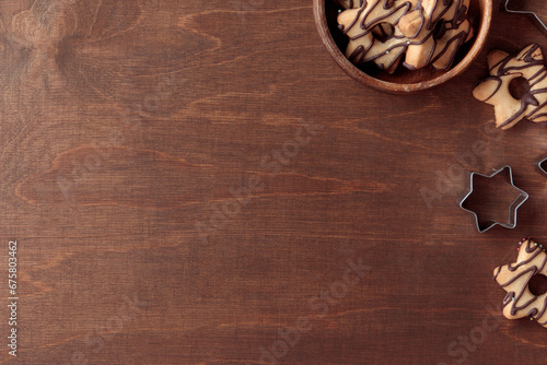 Wooden background with fresh baked homemade star-shaped cookie, wooden bowl and cutters