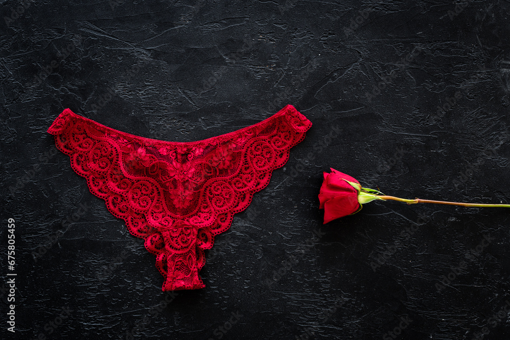 Elegant red lace lingerie bikini panties with red rose, top view - obrazy, fototapety, plakaty 
