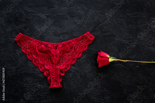 Elegant red lace lingerie bikini panties with red rose, top view