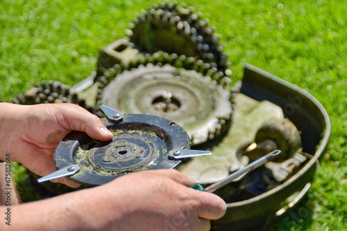 Obraz na plátně Person has removed the knives from the robotic lawnmower and is holding them in his hand