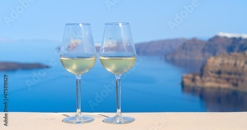 two glasses of white wine with Aegaen sea in background  Greece
