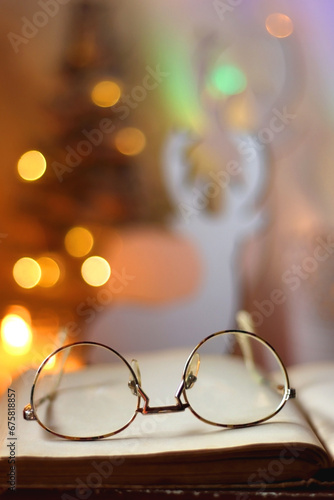 Various colorful Christmas decorations, soft blanket, cup of tea, sweet snacks and lit candles on the table. Cozy Christmas atmosphere at home. Selective focus.