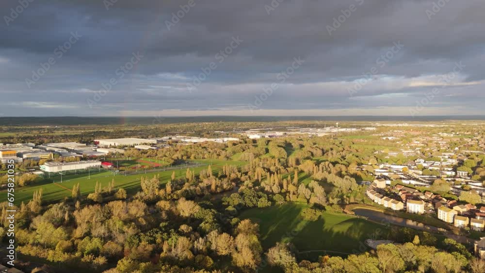 Flying over Gloucester Park at sunset towards the rainbow in the cloudy sky Flying over Gloucester Park at sunset towards the rainbow in the cloudy sky
