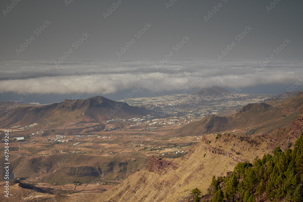 View of Galdar village, la Atalaya mountain and the coast of Gran Canaria shot from Llanos de la Mimbre viewpoint in a cloudy day.
