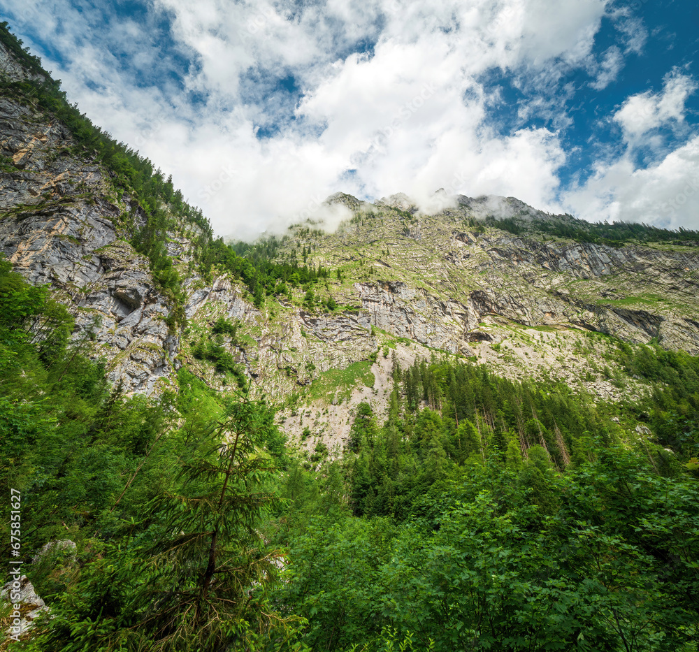 Obraz premium View to the high Berchtesgaden mountain peaks with cloudy sky at the background