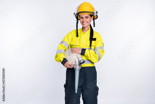 Photo of young attractive woman firefighter happy positive smile hold hose protection isolated over white color background photo