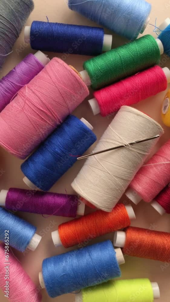 Close up of colorful spools with threads and needle for sewing, rotating motion, vertical video
Close up of colorful spools with threads and needle for sewing, rotating motion, vertical video