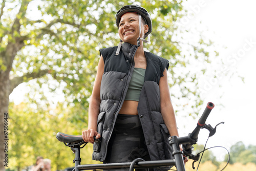Smiling woman wearing bike helmet in park