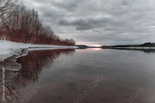 snow-covered trees on the river bank in winter