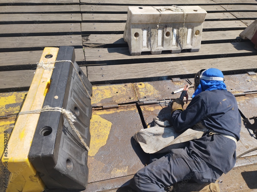 welder employee working on a metal sheet aluminum iron carbon steel