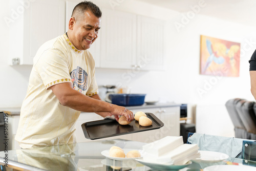 Man holding tray of freshly baked buns