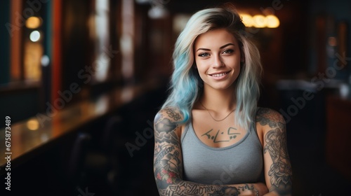 Beautiful young woman with tattoos on her body stands and smiles at the camera. Freelance designer photo