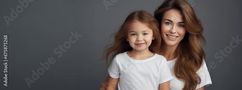 Generative AI image of a young beautiful mother (girl with brown hair, 25-30 years old, in casual white t-shirt) is holding her daughter - a pretty girl of 5 with brown hair and a beautiful smile © Eitan Baron