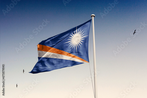 Marshall Islands flag fluttering in the wind on sky.