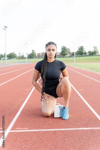Female athlete preparing to run at stadium