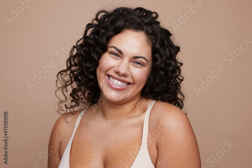 Studio portrait of smiling young woman with curly hair