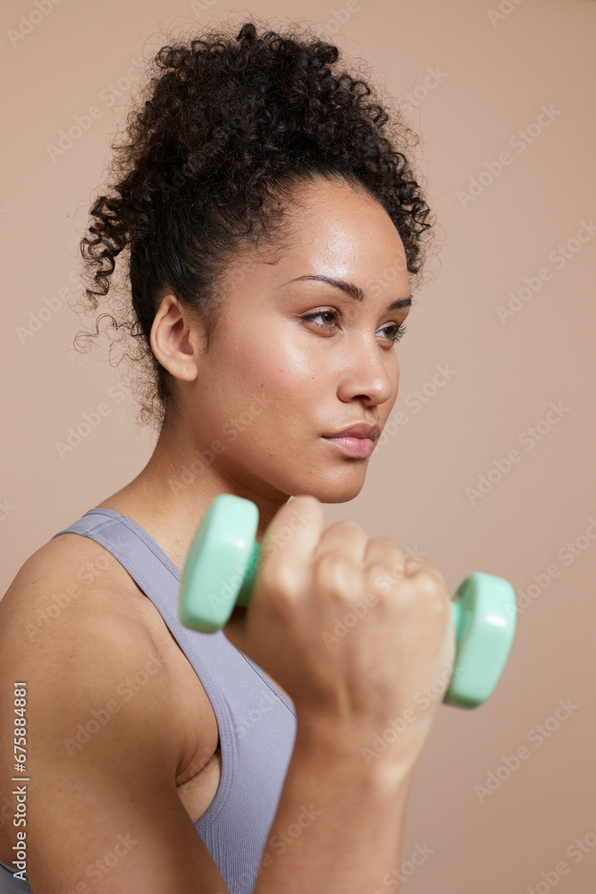 Studio portrait of woman exercising with dumbbells Studio portrait of woman exercising with dumbbells