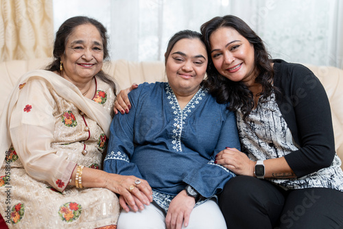 Family portrait with down syndrome woman on sofa at home