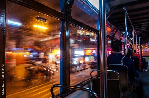 Public transport bus with people sitting in it, at night © Wirestock