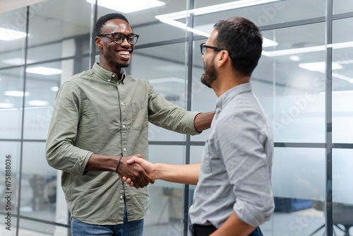 Two men shaking hands in office