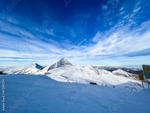 a ski slope covered in lots of snow with clouds in the sky