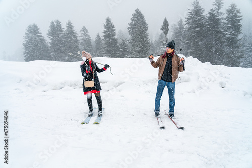 Asian tourist couple on ski and snow of Sonmarg Valley in Himalayas during winter Christmas trip, honeymoon vacation, lover romantic journey. Weather white and snowing. Sonamarg, Jammu, Kashmir, India
