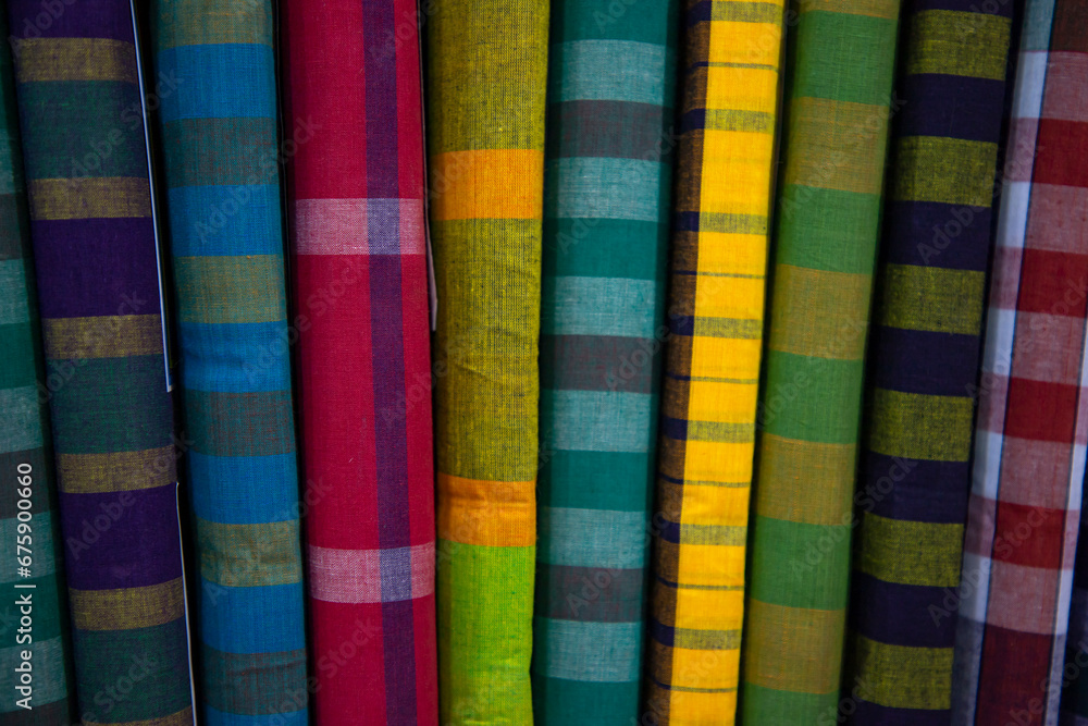 Multicolor Traditional Bangladeshi men's wear lungi folded on a rack in a store. Can be used as  pattern texture background wallpaper