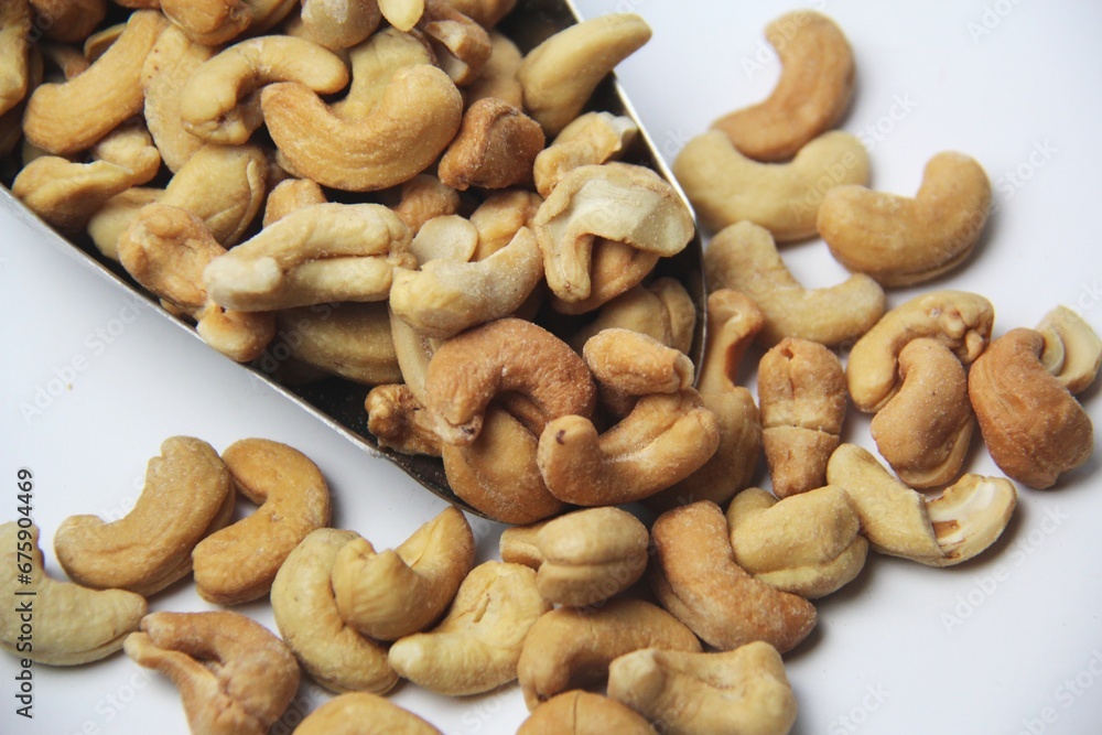 Close-up of roasted cashew nuts (Anacardium occidentale) on a white background. View from above. Native of Brazil. Rich in magnesium, iron, zinc, selenium, vitamin A, E and antioxidants. Close-up of roasted cashew nuts (Anacardium occidentale) on a white background. View from above. Native of Brazil. Rich in magnesium, iron, zinc, selenium, vitamin A, E and antioxidants.