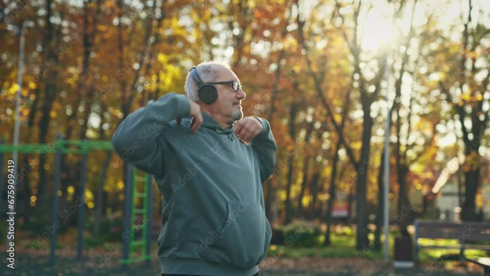 An elderly man in good spirits is exercising outside. Grandpa is having fun doing sports An elderly man in good spirits is exercising outside. Grandpa is having fun doing sports