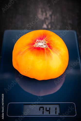 digital scale with orange pineapple tomato on it photo