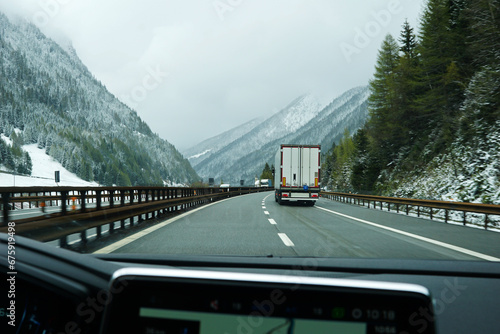 Snowy mountain cliff and cloudy sky with traffic view on Brennero Autostrada motorway to Innsbruck, Medieval old town in the capital of Austria’s western state of Tyrol, Europe photo