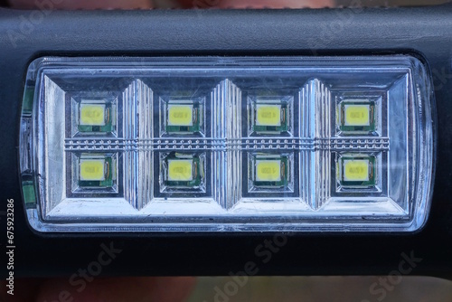 a row of small green square LED light bulbs on a gray black panel of an electrical appliance