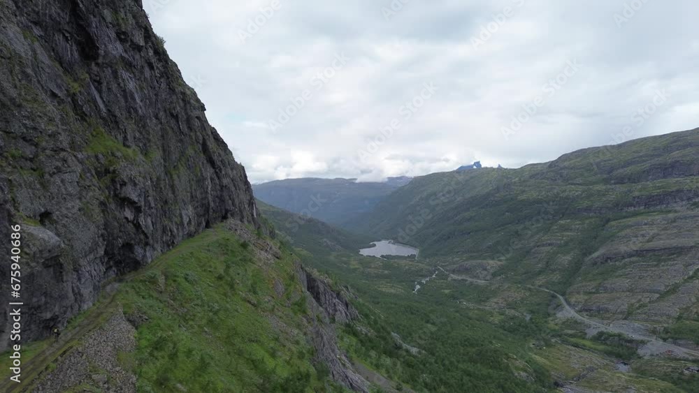 Cyclist Riding On The Edge Of A Cliff In Norway, Aerial View Cyclist Riding On The Edge Of A Cliff In Norway, Aerial View