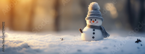 süßer kleiner Schneemann im Schnee mit Mütze und Schal im Schnee photo