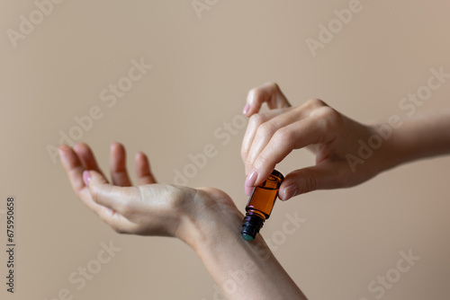 Woman applying natural rollerball aroma oil on her wrist close up	