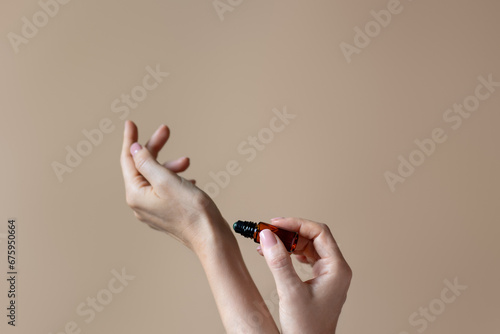 Woman applying natural rollerball aroma oil on her wrist close up	 photo