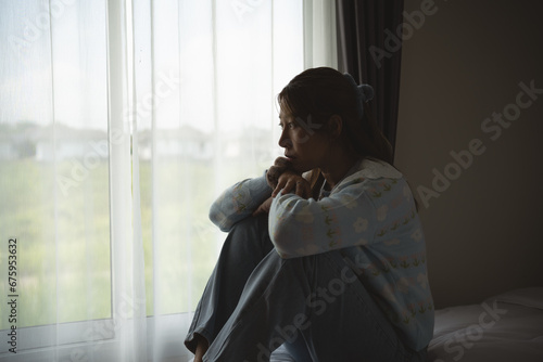 Silhouette depressed woman sadly sitting on the bed in the bedroom. Sad asian women suffering depression insomnia awake and sit alone on the bed in bedroom. Depression health people concept.