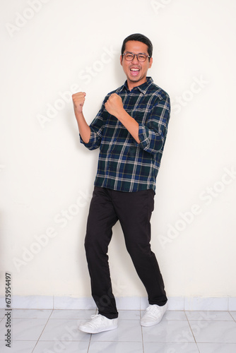 Full body portrait of a man standing with excited expression photo