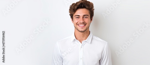 The young man in a white shirt with a smiling face and vibrant eyes is standing up against an isolated white background ready for his business presentation where he will showcase his innova