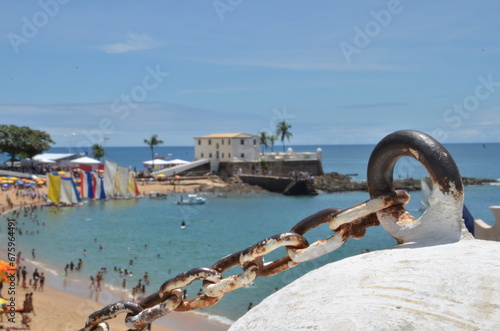 Rusty chains with old fortress and traditional boats in the background