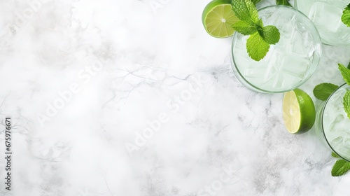 Mojito cocktail alcohol bar long drink traditional Cuba fresh tropical beverage top view copy space two highball glass, with rum, spearmint, lime juice, soda water and ice on white concrete table.