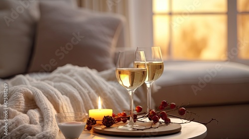  two glasses of wine and a candle on a tray on a table in front of a couch in a living room.  